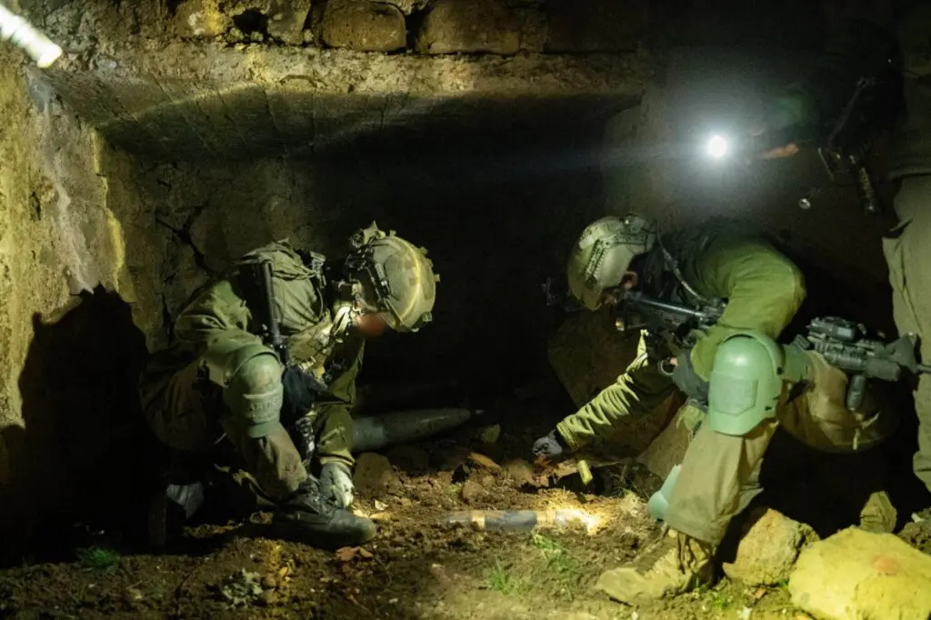 Soldiers inspecting underground area with flashlights.