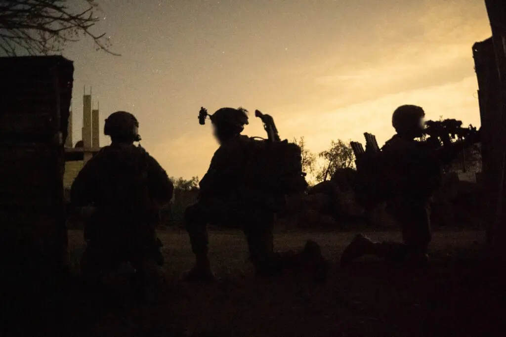 Silhouetted soldiers during a nighttime operation
