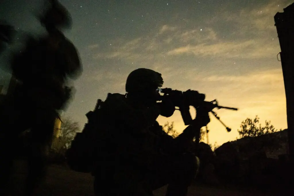 Soldiers in silhouette during nighttime operation.