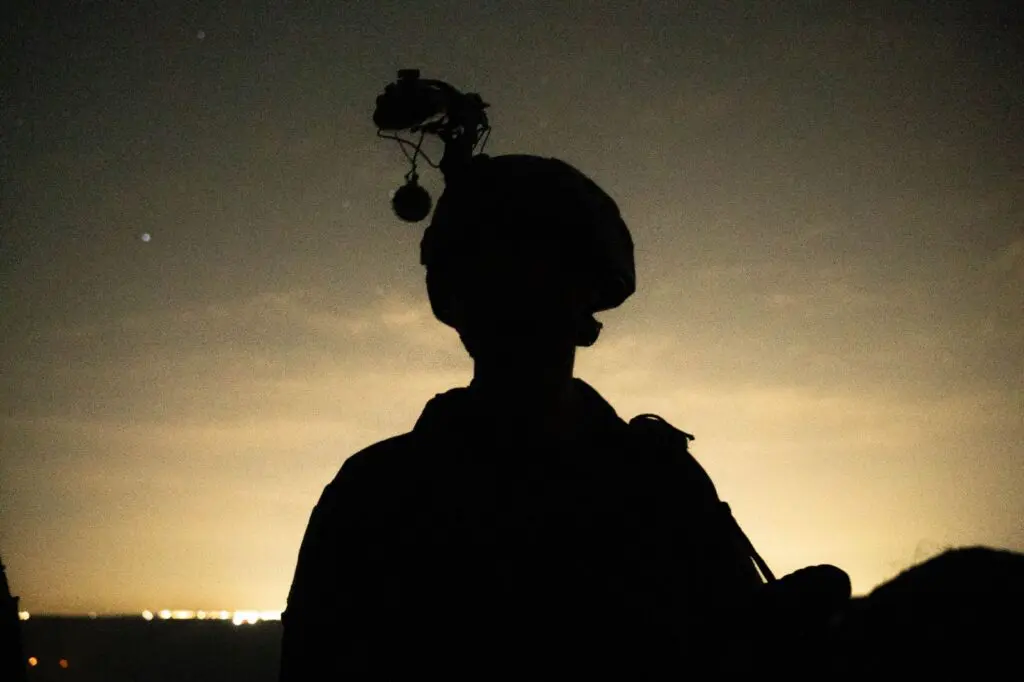 Silhouette of soldier at dusk with helmet equipment.