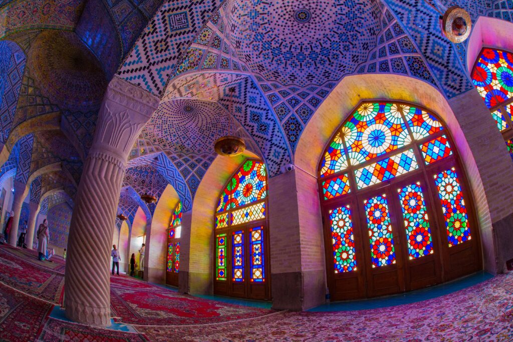 Vibrant stained glass windows in colorful mosque interior.