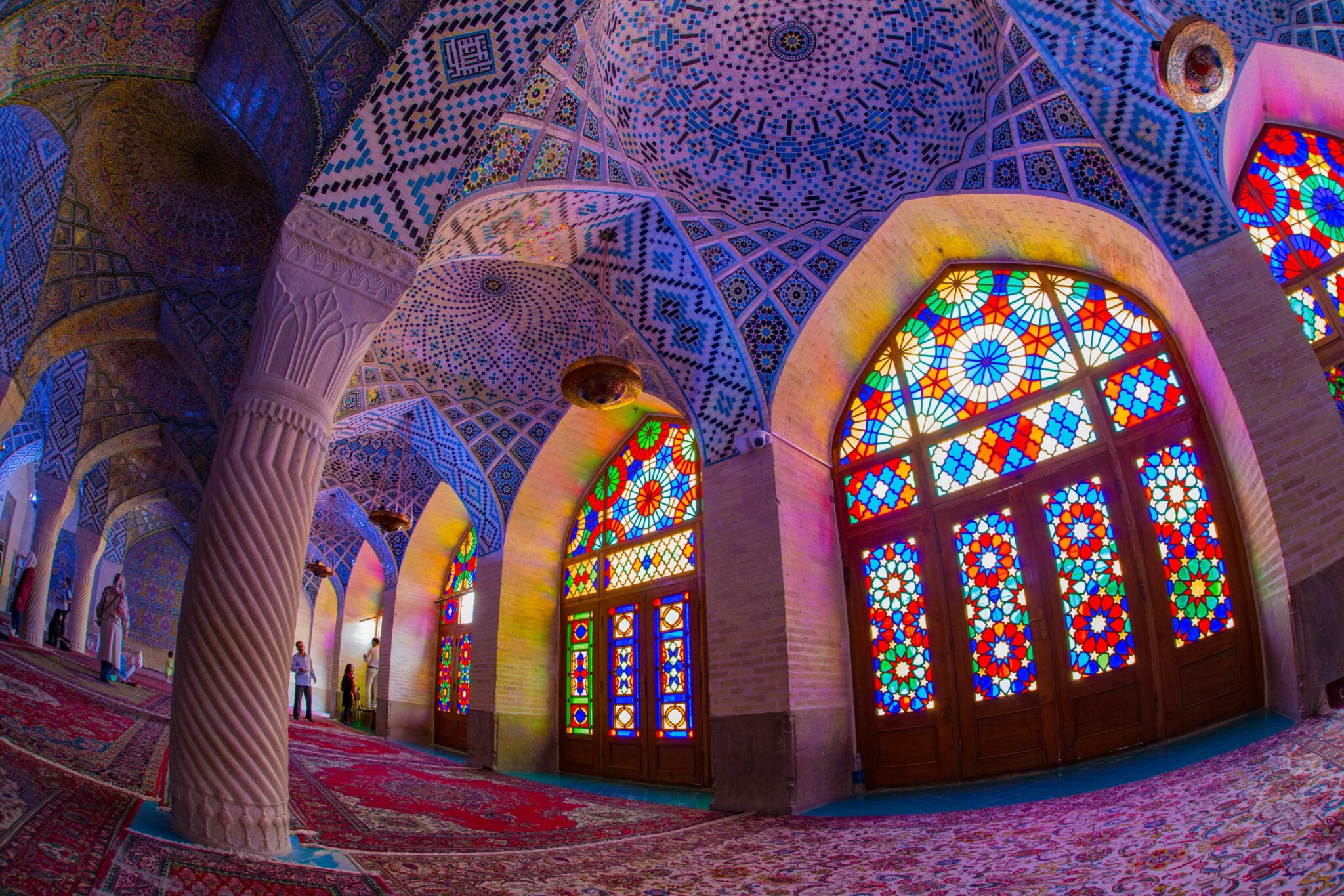 Vibrant stained glass windows in colorful mosque interior.