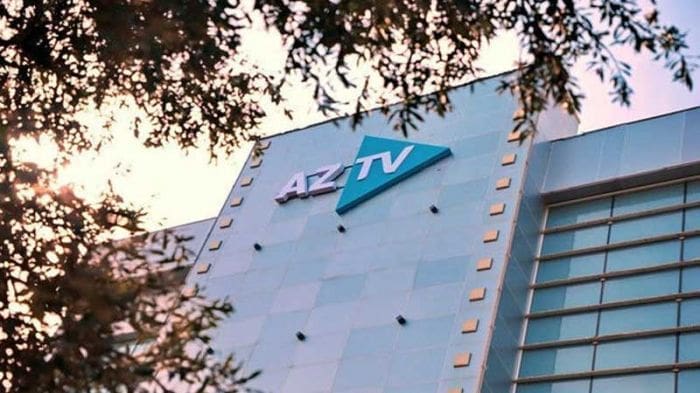 AZTV building with logo and trees.