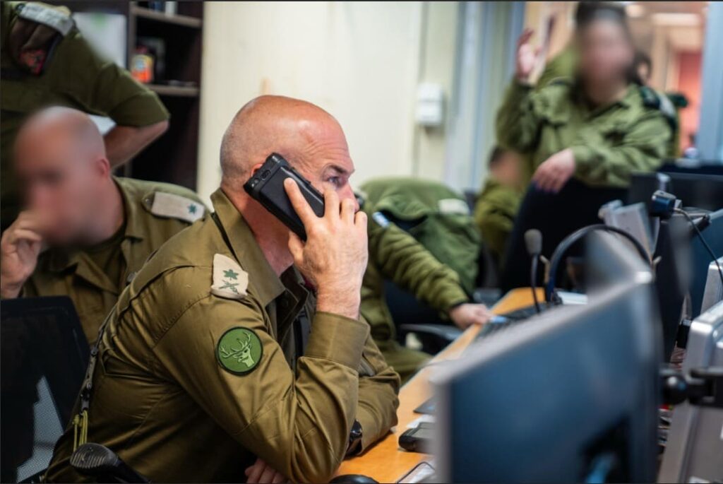 Military personnel communicating using phone in command center.