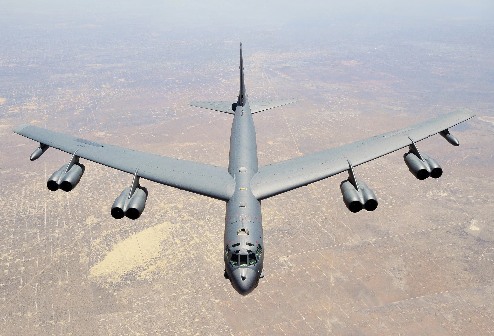 Military bomber aircraft flying over desert terrain