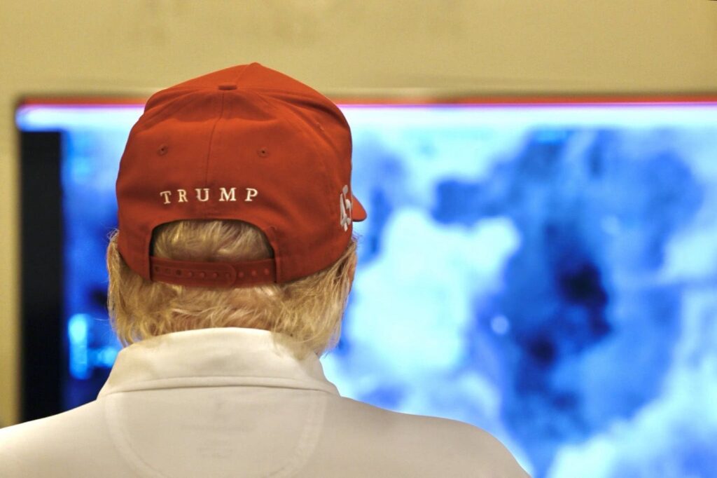 Person in red cap views screen