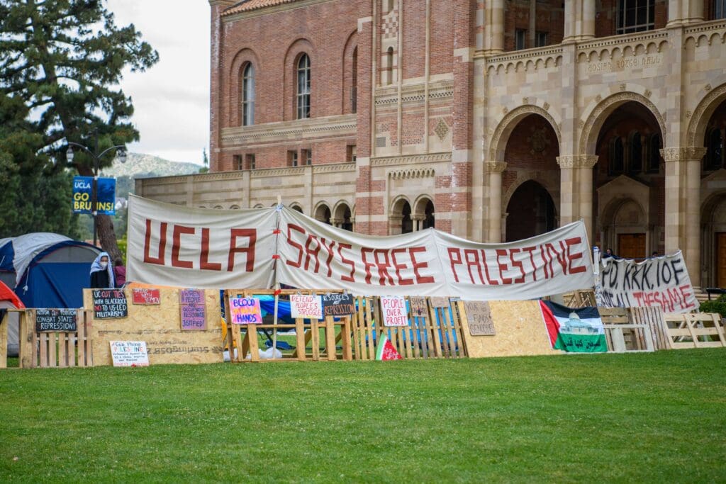 Protest banners with 'UCLA Says Free Palestine' displayed.