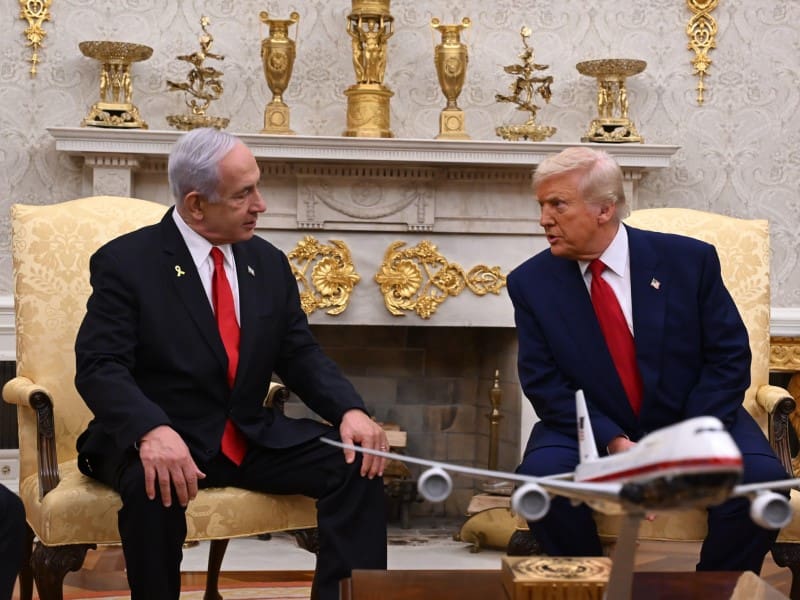 Two men in suits discussing in a formal room.